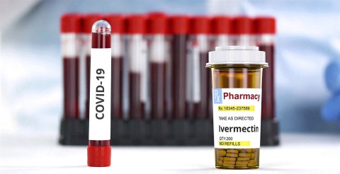 An image showing blood vials labelled "Covid-19" beside a bottle of ivermectin tablets