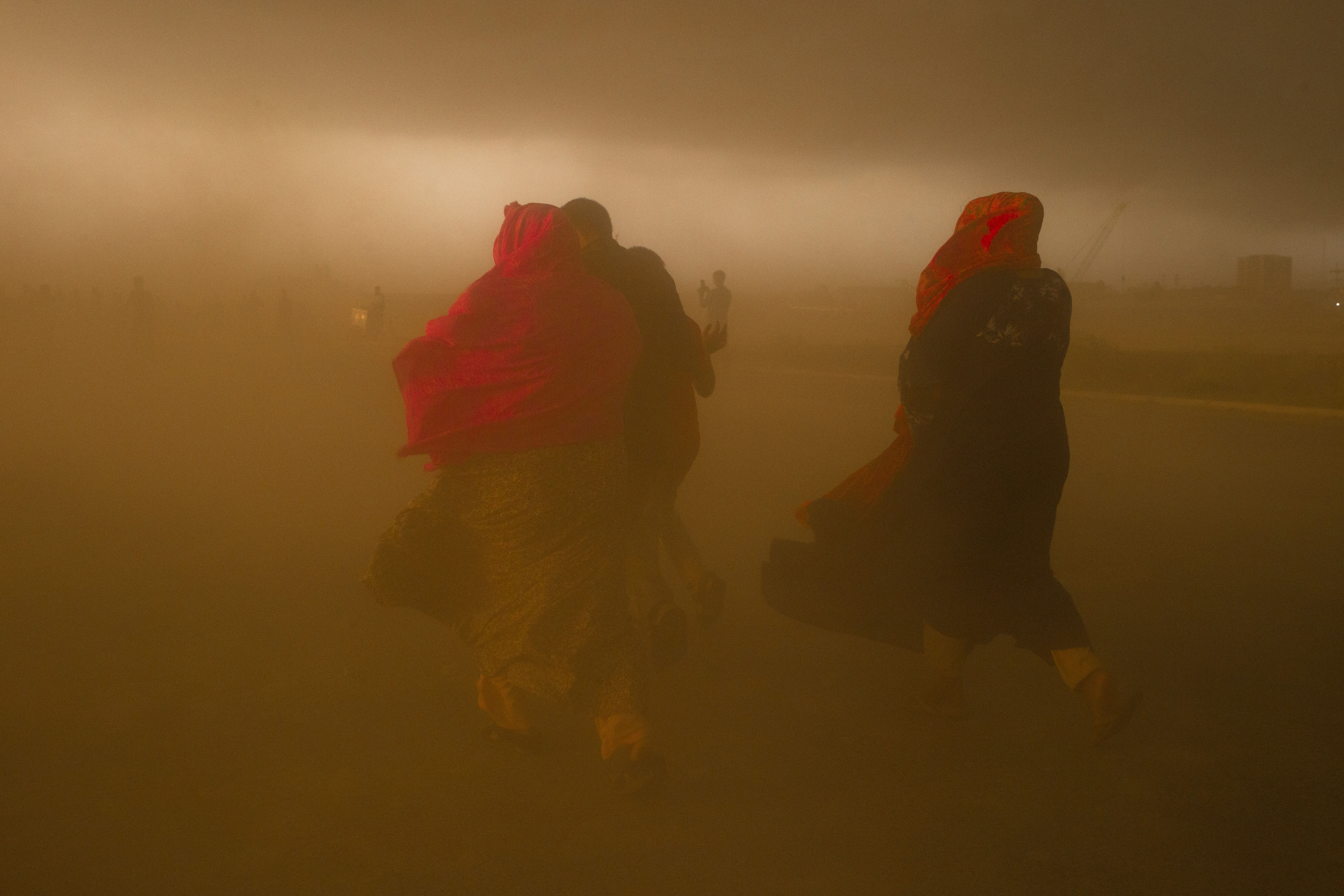 People run in search of shelter during a sandstorm.
