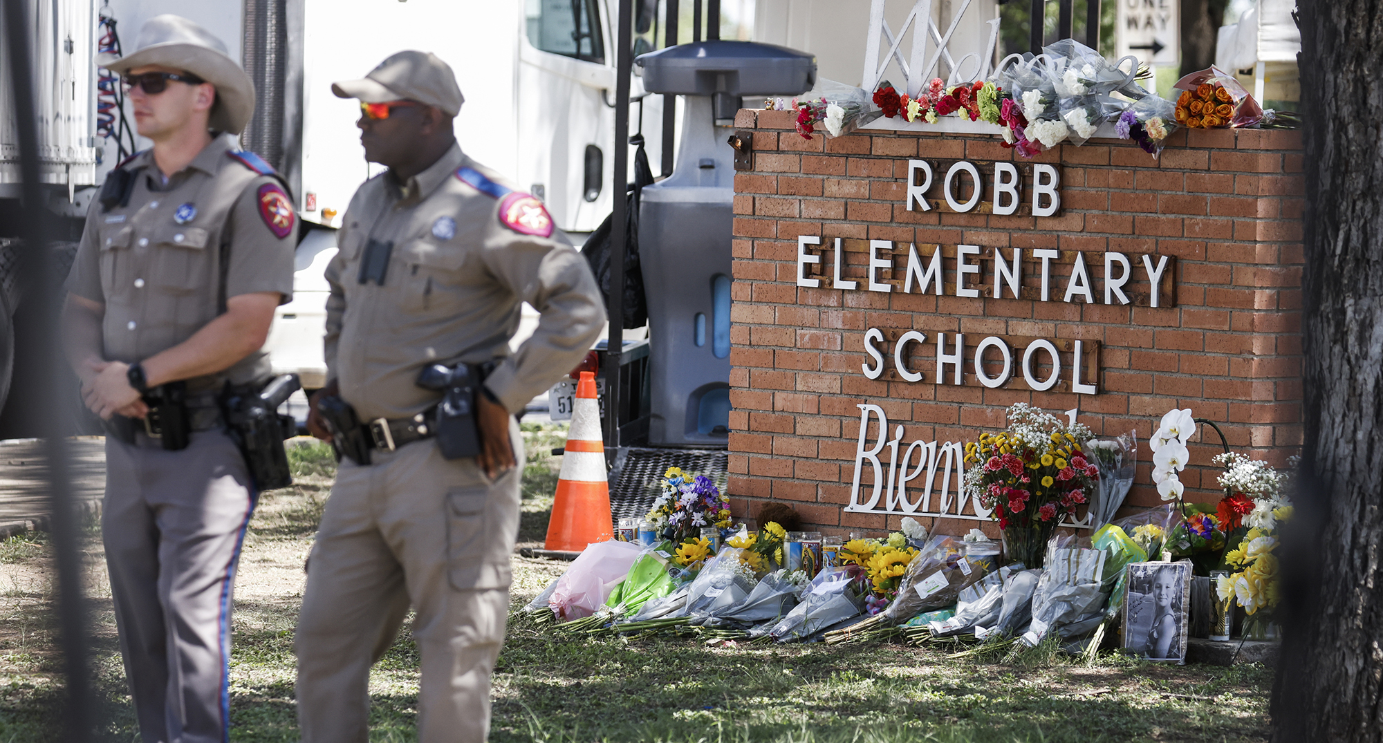 Texas police officers stand in front of the memorial outside Robb Elementary School in Uvalde, Texas