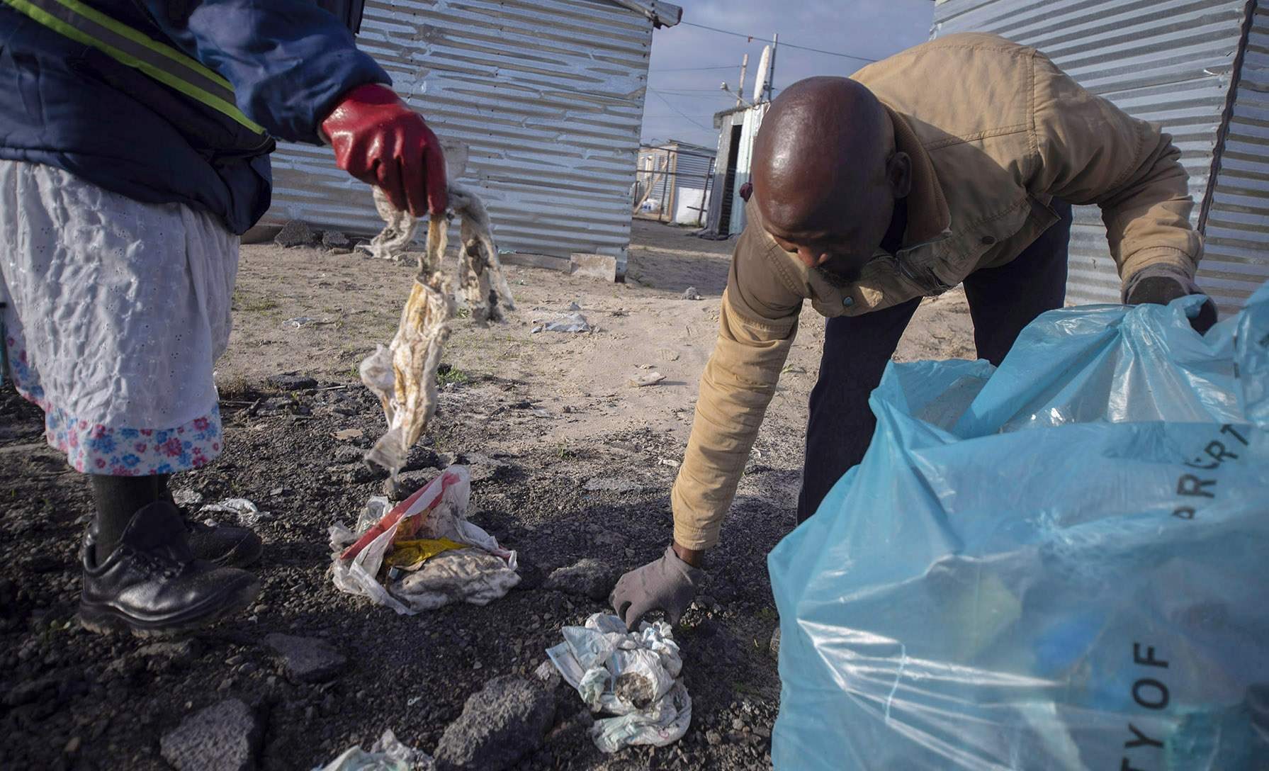 Volunteers collect litter and debris from within the informal settlement