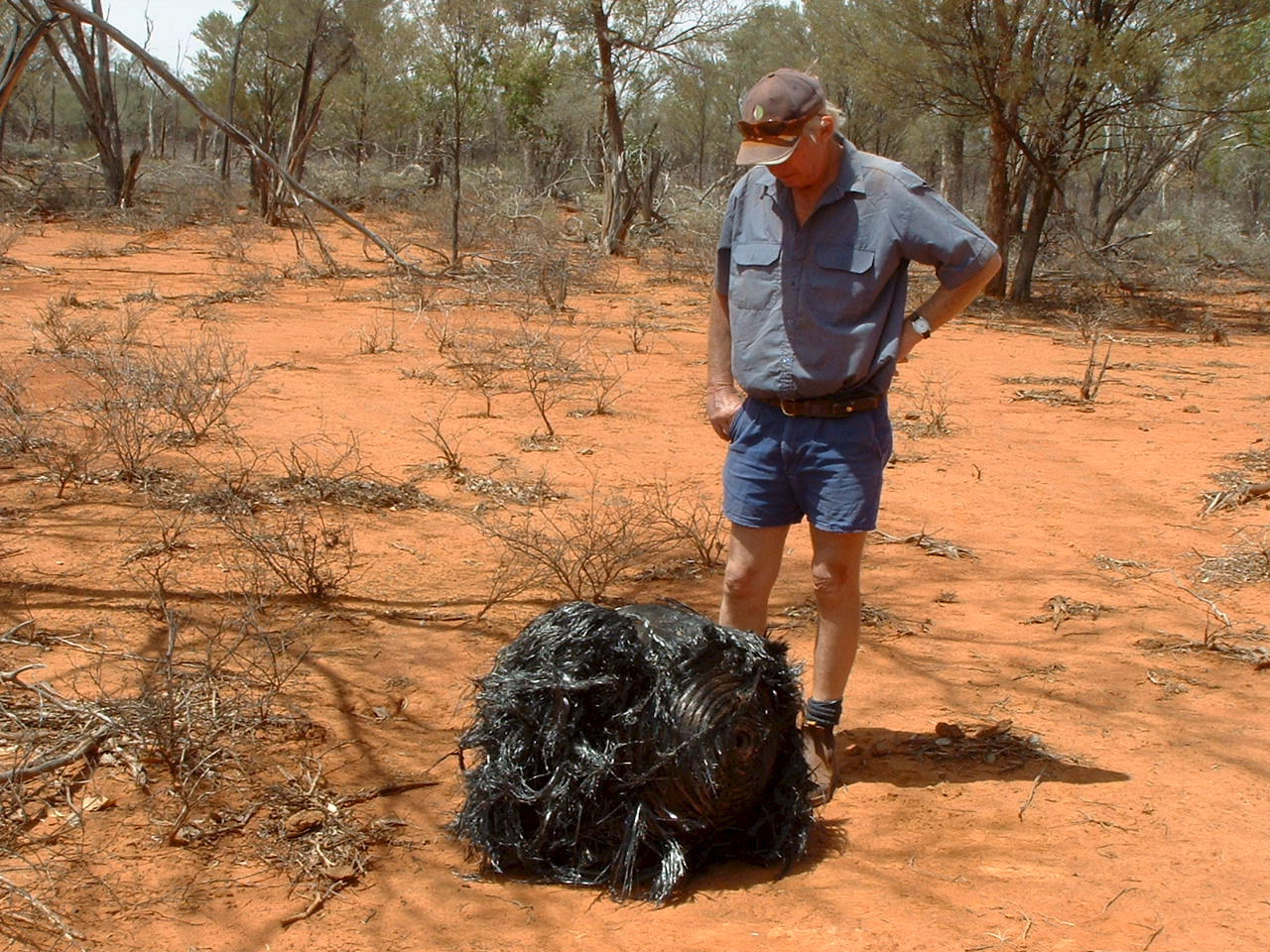 Farmer James Striton next to a metal object he discovered on his farm in Cheepie, 130km from Charleville in southwestern Queensland in November 2007. The ball of twisted metal is believed to be space junk, possibly from a rocket used to launch satellites into space.