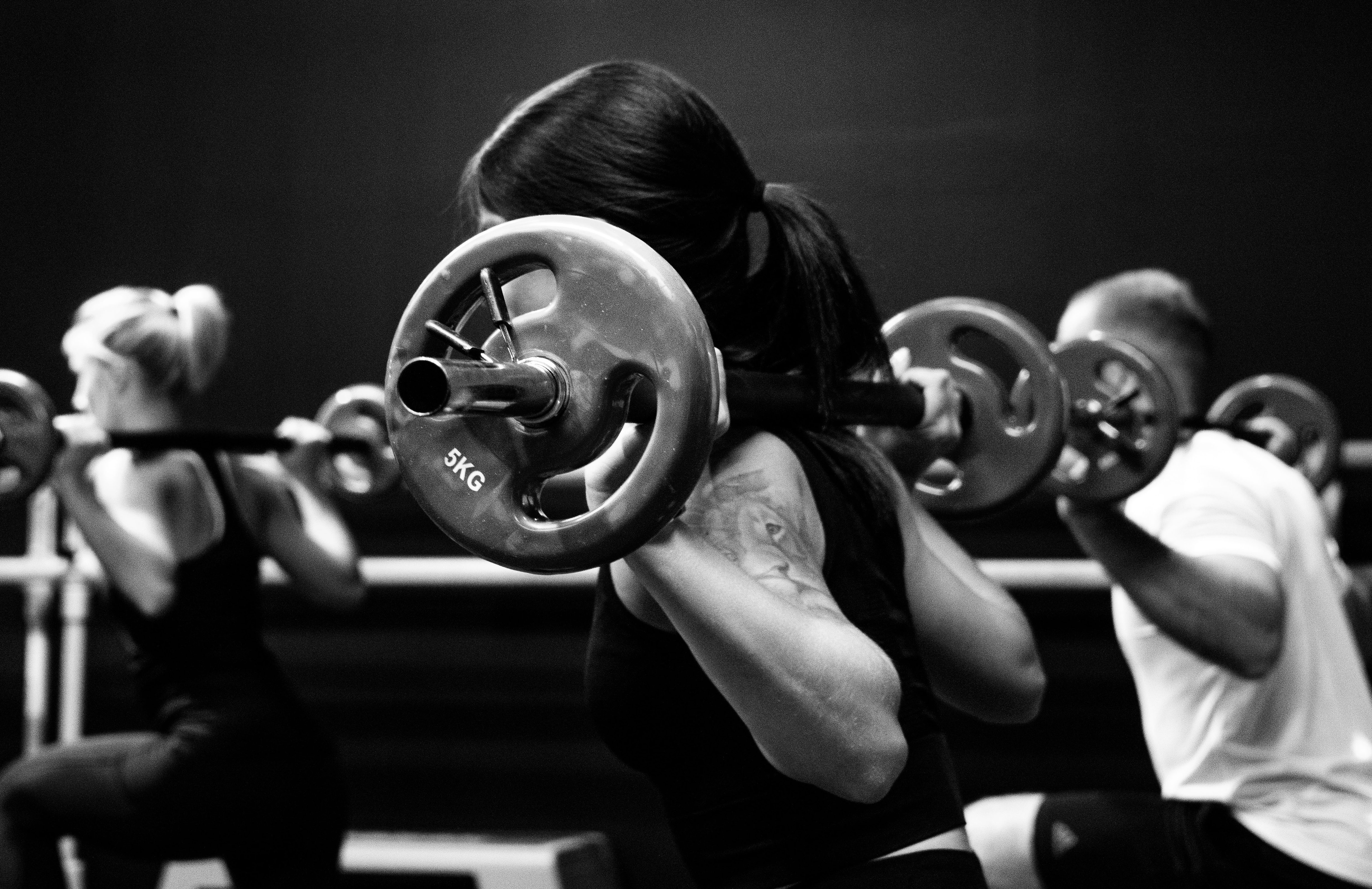 Black and white image of a person lifting weights