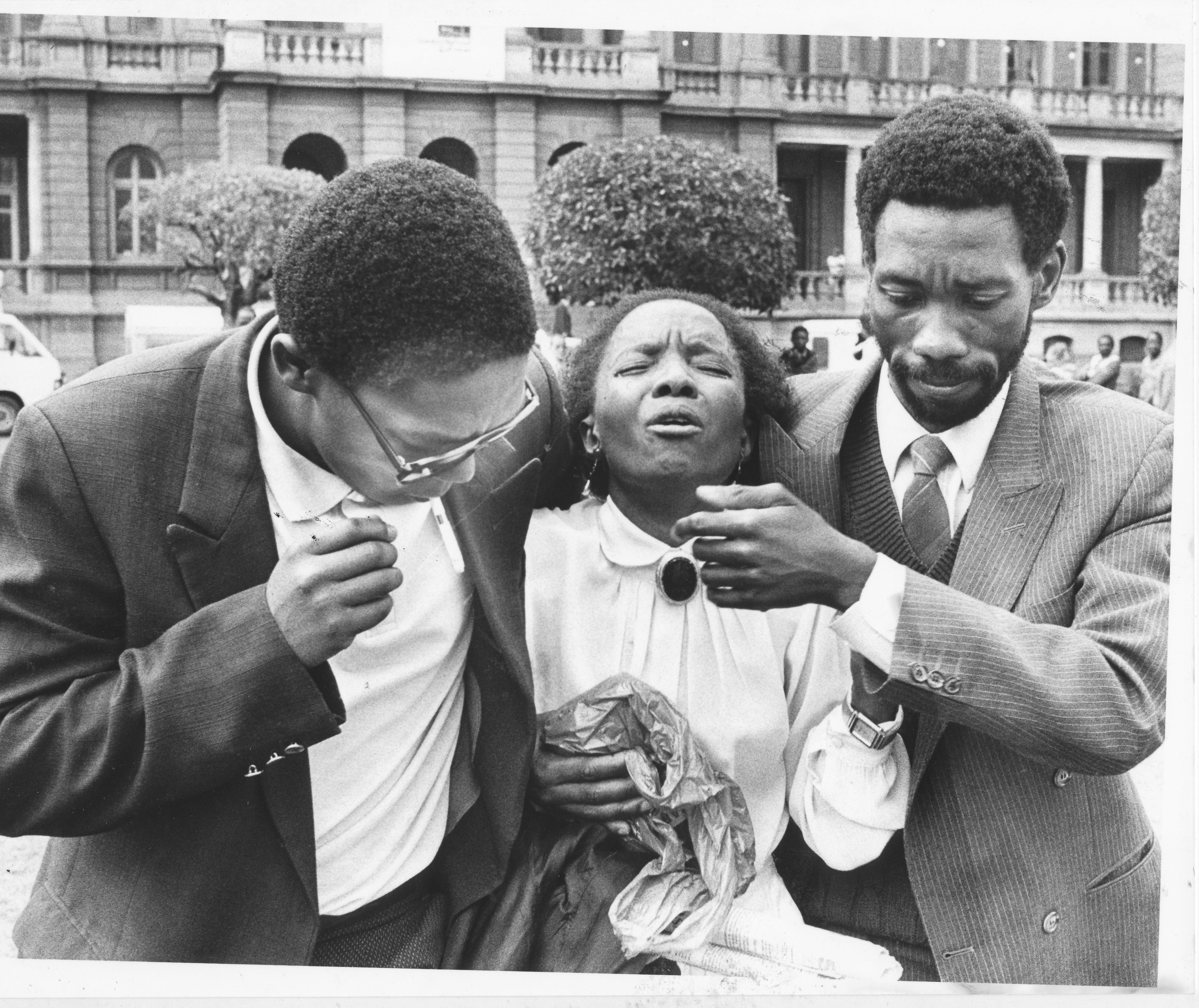 PRETORIA, SOUTH AFRICA - NOVEMBER 19: Mr Simon Nkoli (right) , one of the accused who was acquitted of all the charges comforts Miss Maticho Mokoena sister of John Sekwati Mokoena who was found guilty of terrorism at the Delmas Trial on November 19, 1988 in Pretoria, South Africa. (Photo by Gallo Images/Drum/E Mboweni)