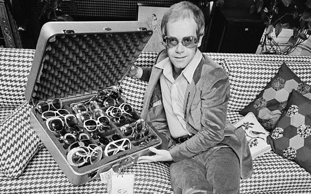 12th September 1974: English pop star Elton John with a suitcase of his trademark sunglasses. (Photo by D. Morrison/Express/Getty Images)