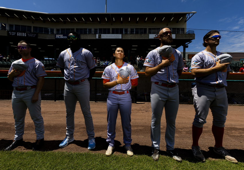 Kelsie stands with her teammates before their game against the Long Island Ducks at Fairfield Properties Ballpark, Central Islip, New York, on 7 July 2022. Kelsie Whitmore is the first female professional baseball player to play in an all-male pro league. She plays outfield and pitches for the Staten Island Ferryhawks in the Atlantic League of professional baseball. Her debut in the Atlantic League was as a pinch runner on 22 April 2022, and on 1 May she became the first woman to start an Atlantic League game, when she played as a left fielder. Just three days later she was the first woman to pitch in an Atlantic League game and on 3 September 2022 Kelsie became the first woman to record a hit in association with Major League Baseball. © Al Bello, United States, Finalist, Professional competition, Sport, Sony World Photography Awards 2023 