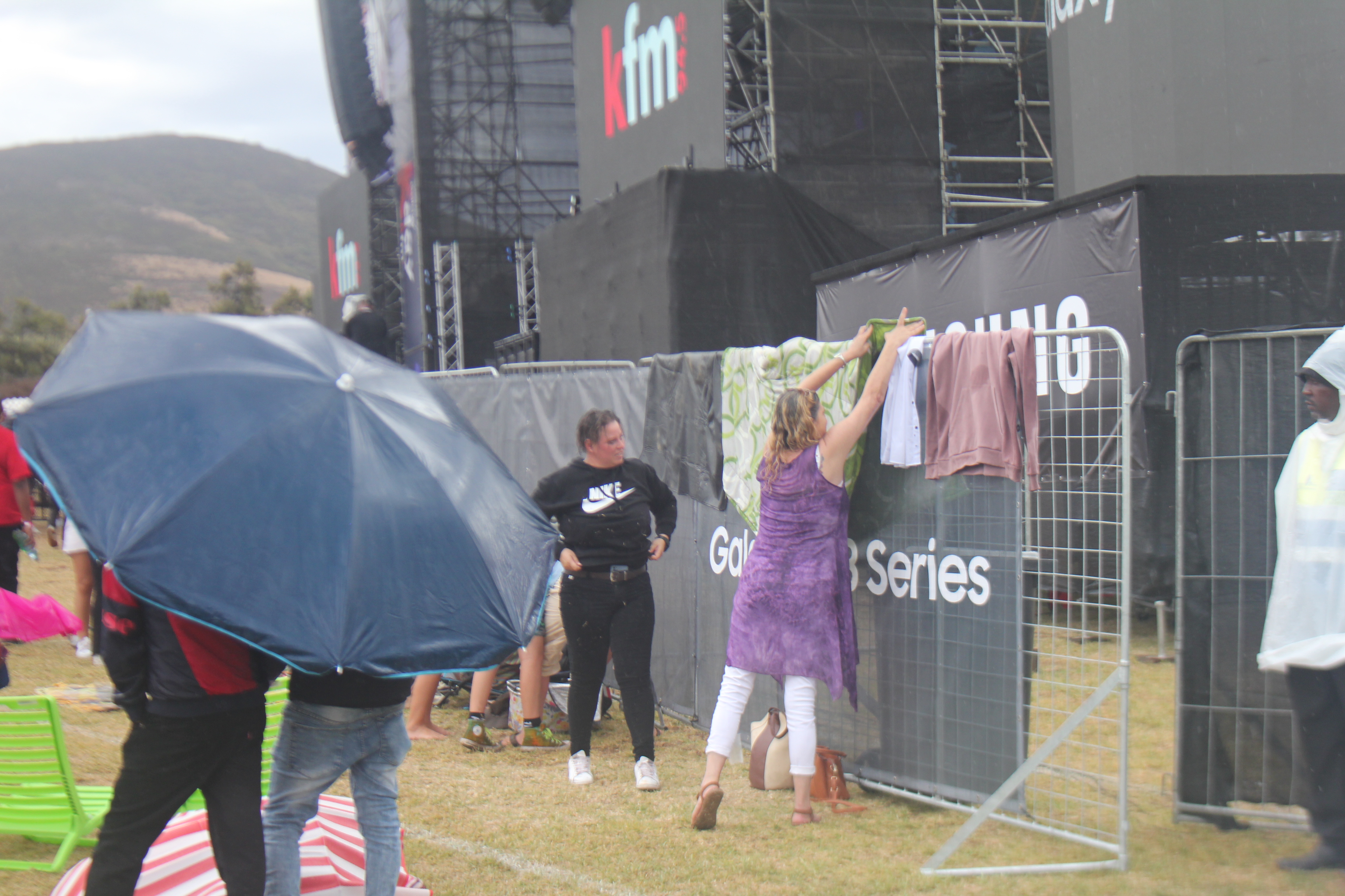 Festival goers hang up picnic blankets and some clothes after rain hit the Galaxy KDay Festival. Image: An Wentzel