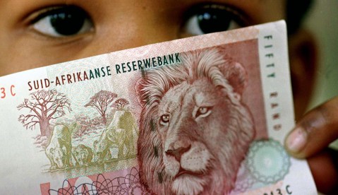 A South African child holds a 50 rand note July 2. The rand sank to a fresh low against the dollar i..